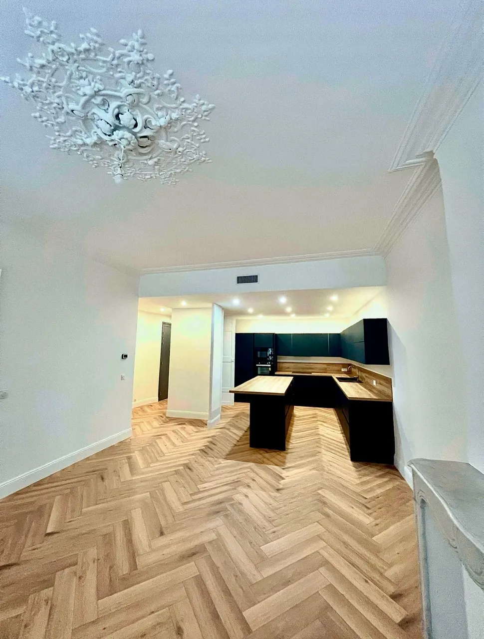 Cuisine noire moderne avec parquet en chevrons et moulures