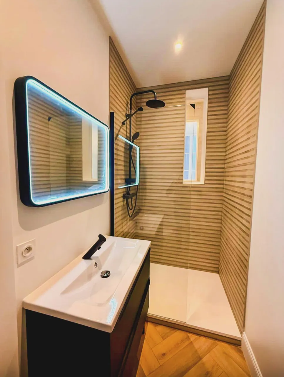 Salle de bain rénovée avec miroir LED et douche à l'italienne